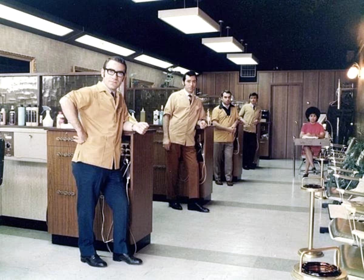 Five barbers in matching shirts lined up inside Madison Men's Hair Stylist