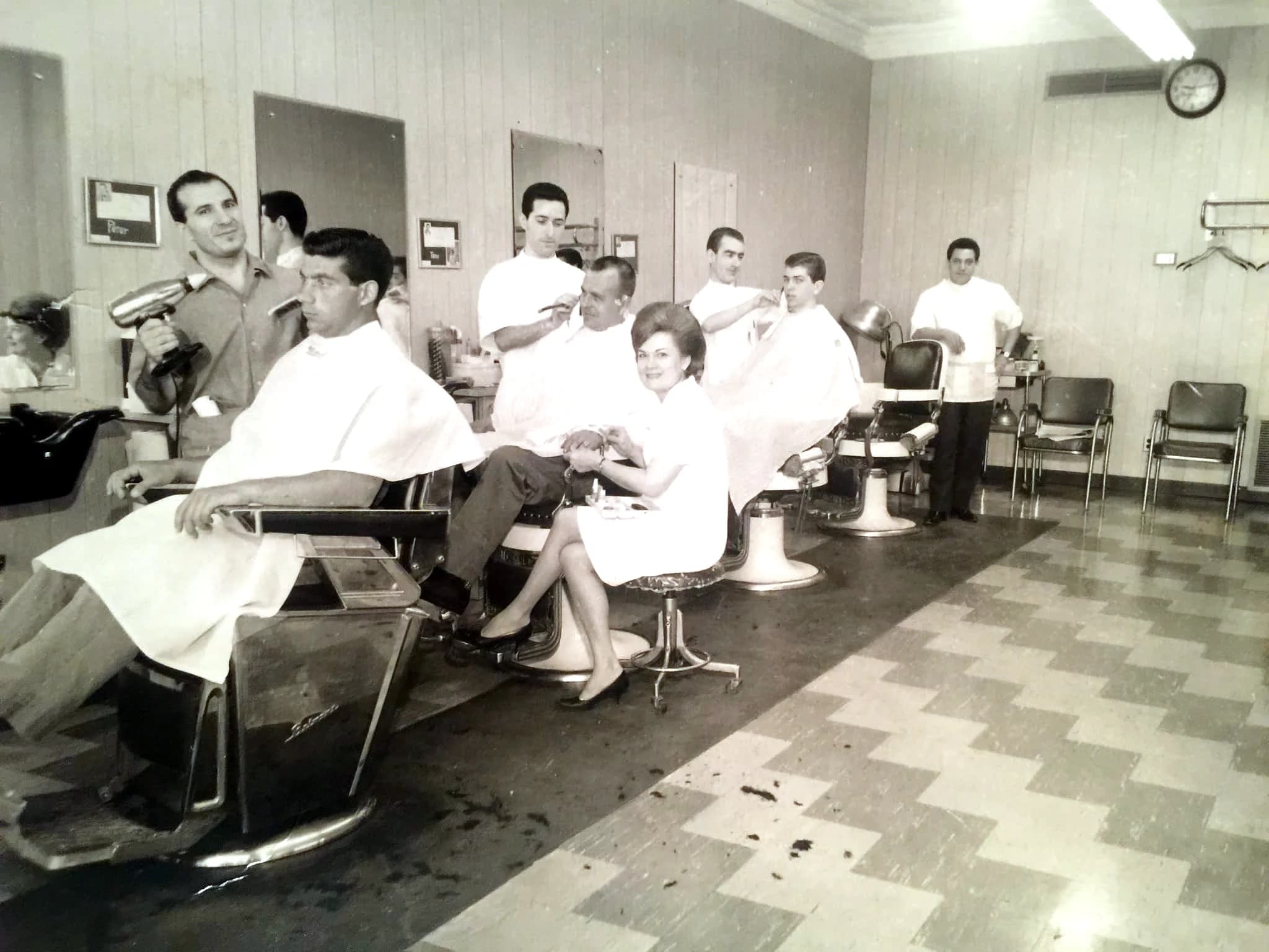 Madison Men's Hair Stylist in full swing — five barbers working, a manicurist mid-set, checkerboard floor